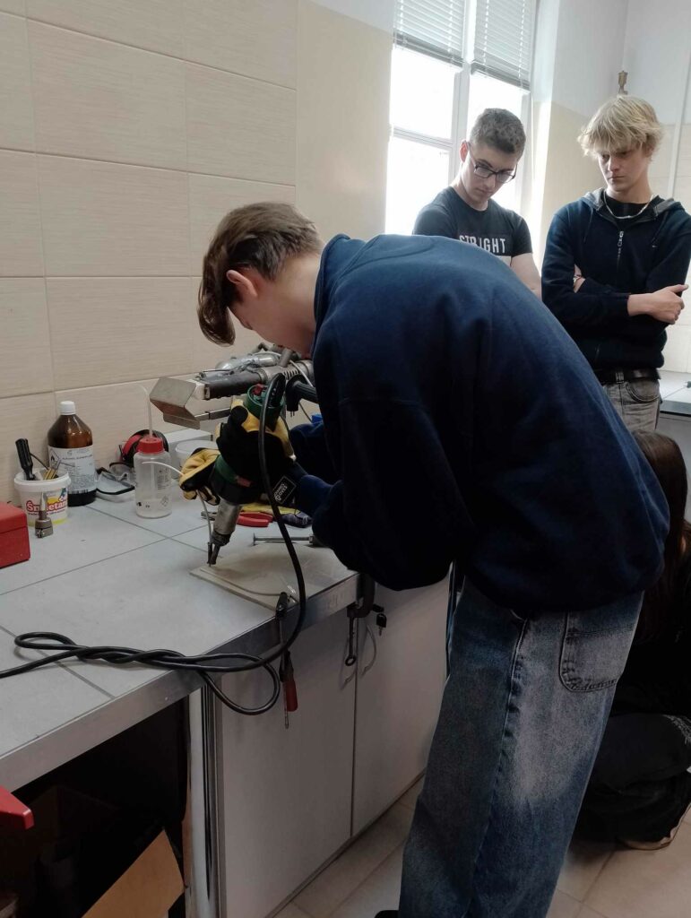 Uczniowie na uniwersytecie wykonują eksperymenty z polimerami
