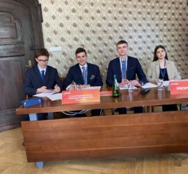 uczniowie przy stole prezydialnym w trakcie debaty